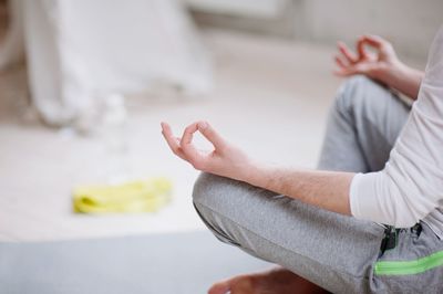 Low section of man doing yoga in studio