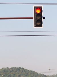 Low angle view of road signal against sky