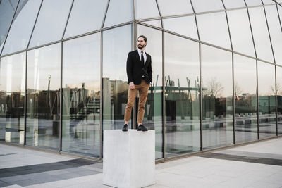 Portrait of young man against glass wall