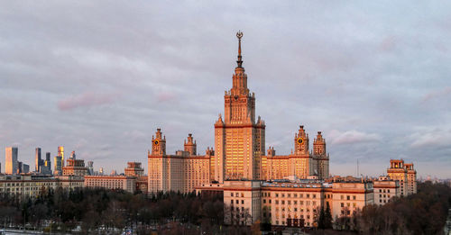 Aerial panoramic view of sunset reflection in windows of moscow university under dramatic cloudy sky