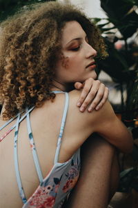 Midsection of woman looking away while sitting outdoors