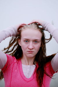 Portrait of serious young woman with hands in hair during foggy weather