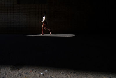 Full length of woman with arms raised at night