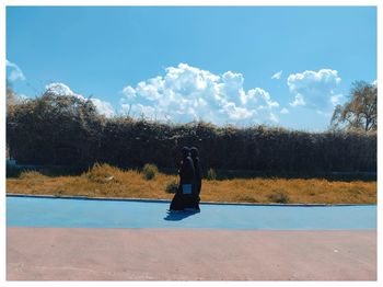 Side view of man on plants against sky