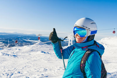 Smiling woman gesturing at ski park