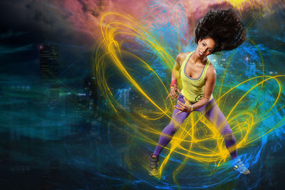 Digital composite image of woman dancing against colored background 