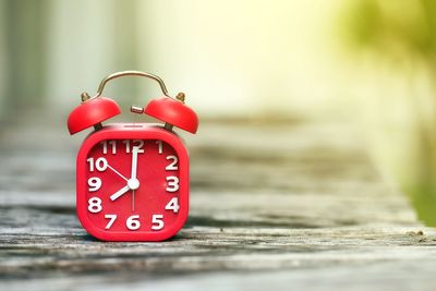 Close-up of clock on weathered wooden table