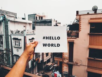 Low section of person holding text on building in city