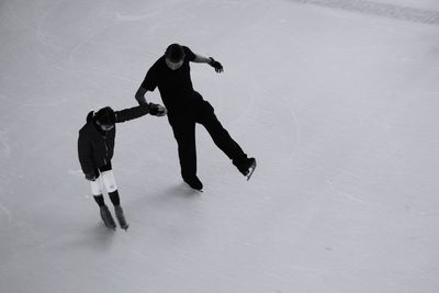 High angle view of father and son ice-skating on rink