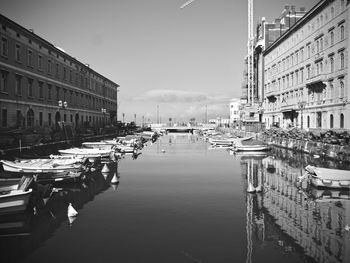 Canal amidst buildings in city against sky
