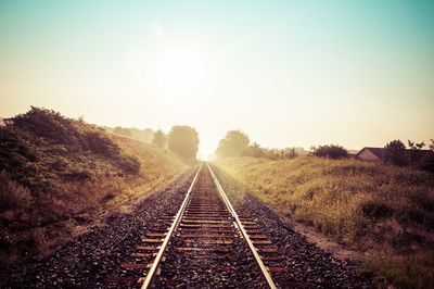 Railroad tracks against sky during sunset