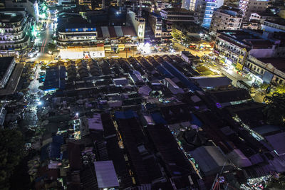 High angle view of illuminated street amidst buildings at night