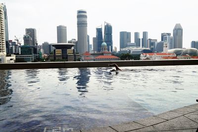 View of swimming pool by buildings against sky