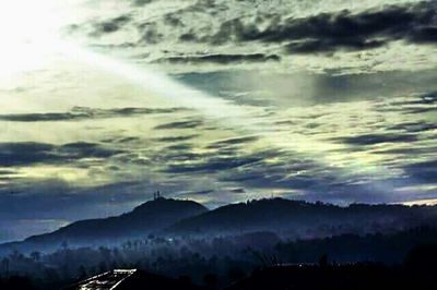 Scenic view of mountains against cloudy sky