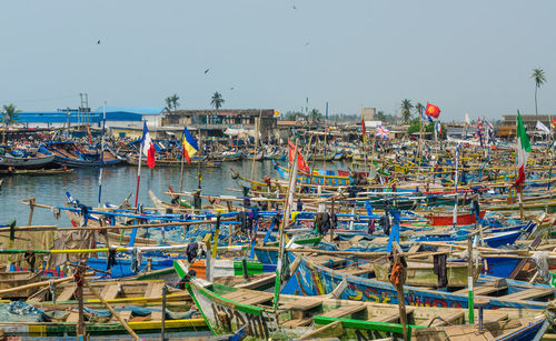 Boats moored at harbor against clear sky