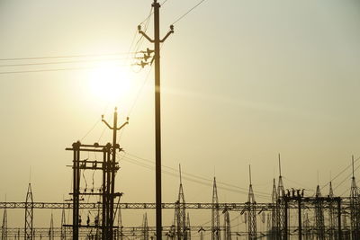 Electricity pylon against sky during sunset