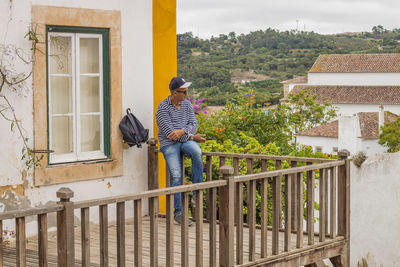 Man standing by railing of house