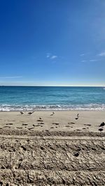 Scenic view of beach against blue sky