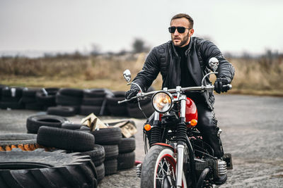 Man riding motorcycle on sunglasses against sky