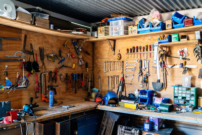 Wooden boards with various instruments and tools of joinery above workbench in modern workshop