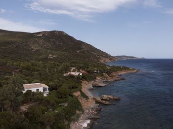 Scenic view of sea by buildings against sky