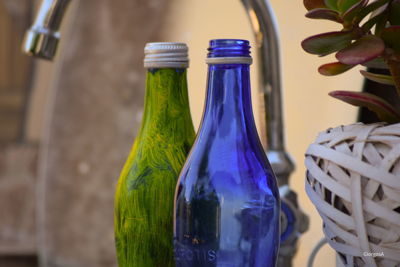 CLOSE-UP OF BOTTLES ON TABLE