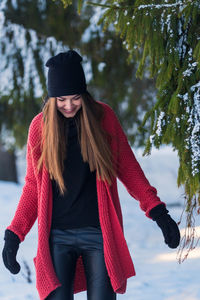 Young beautiful woman wearing warm clothing on snowy field