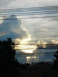 Silhouette of trees against cloudy sky