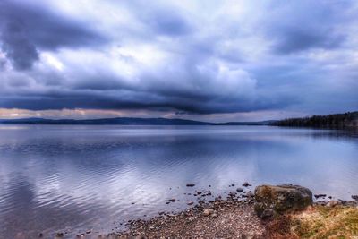 Scenic view of lake against cloudy sky