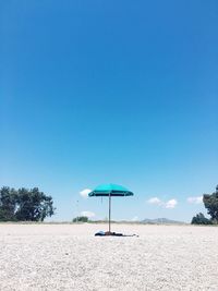 Lifeguard hut on beach against clear blue sky