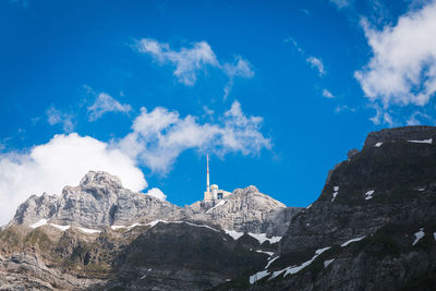 Low angle view of rocky mountains against blue sky