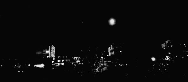 Illuminated buildings against sky at night