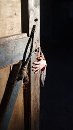 Close-up of hand holding door against black background