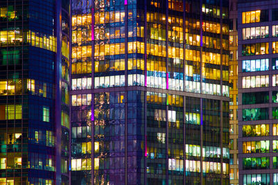 Reflection of illuminated building on glass window at night