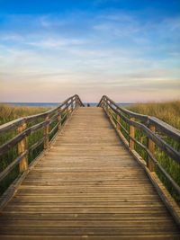 Wooden footbridge against sky