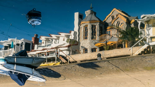 Boats moored in sea against buildings in city