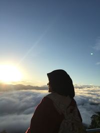 Side view of woman looking at sunset