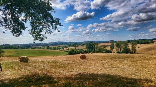 Scenic view of field against cloudy sky