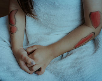 Close-up of baby hand on bed