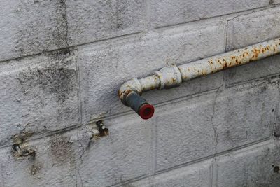 Close-up of rusty pipe on weathered wall