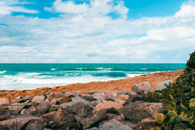 Tropical landscape on a beach with lot of rocks and beautiful cloudy sky