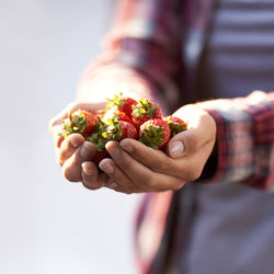 Midsection of woman holding strawberries