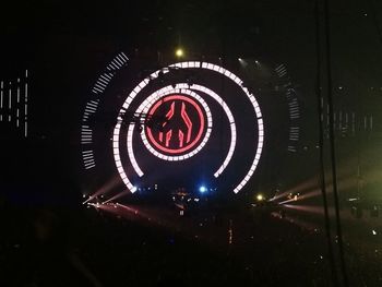 Blurred motion of illuminated ferris wheel at night