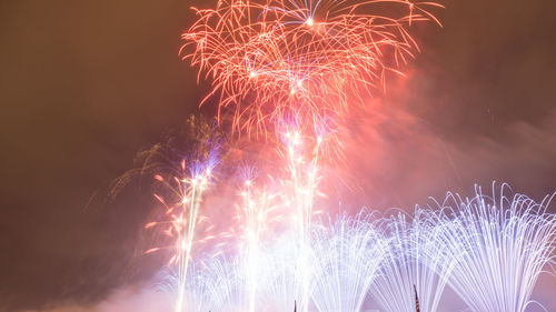 Low angle view of firework display at night