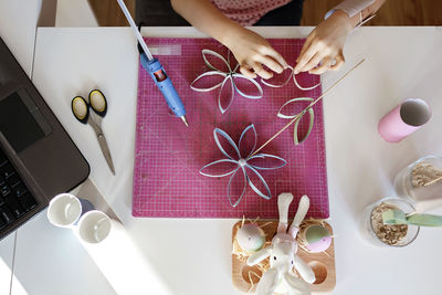 Cropped hands of girl doing craft at home