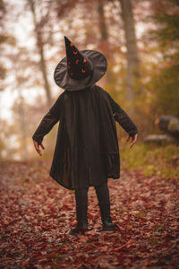 Rear view of woman standing in forest