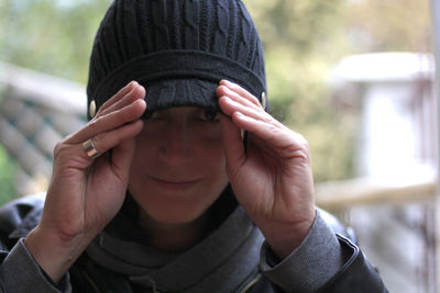 Close-up portrait of smiling woman wearing cap