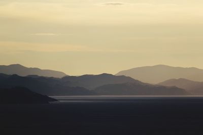 Scenic view of sea and mountains against sky