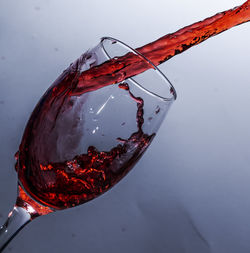 Close-up of red wine glass against white background