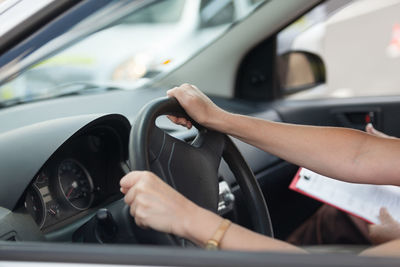 Woman with instructor driving car in city